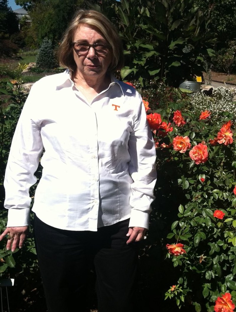 Elizabeth Fugate standing beside a rose bush