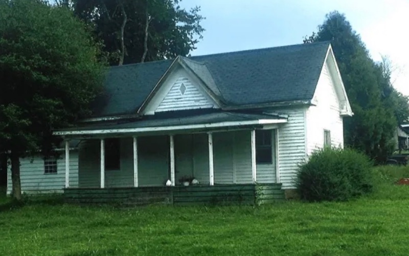 The farmhouse as it stood before it was renovated into the Whitt's Place meat market, with a deep front porch